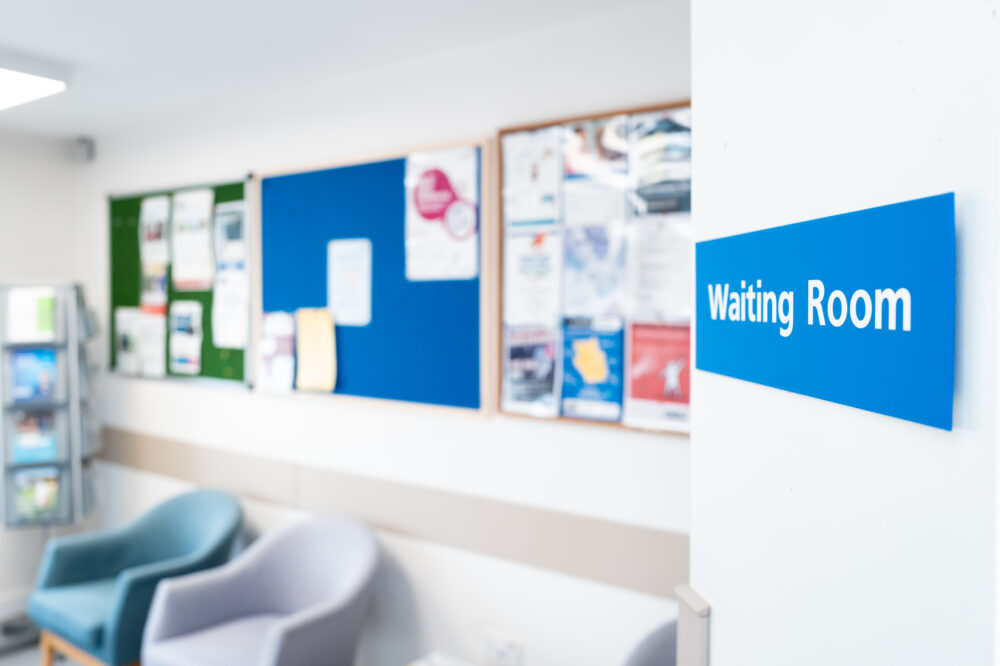 Shallow focus of a typical NHS hospital waiting room sign seen in a British hospital.